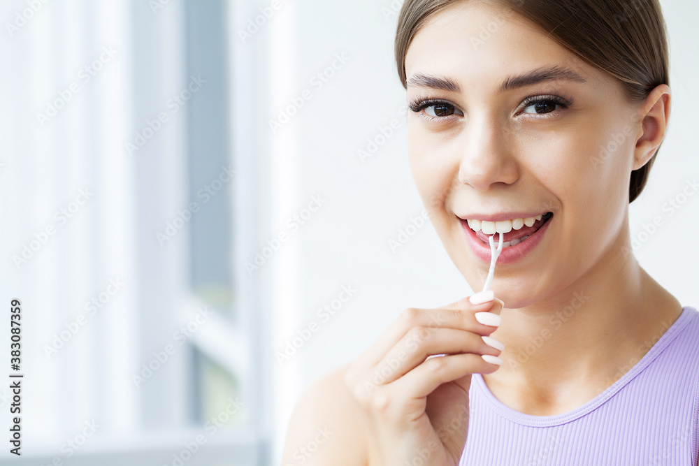 Portrait of beautiful woman cleaning teeth with dental floss Portrait of beautiful woman cleaning teeth with dental floss