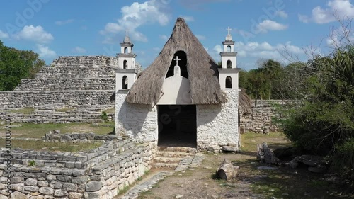 Aerial ascending and pitching down in front of the Catholic church on the grounds of Xcambo Mayan ruins in Mexico. photo