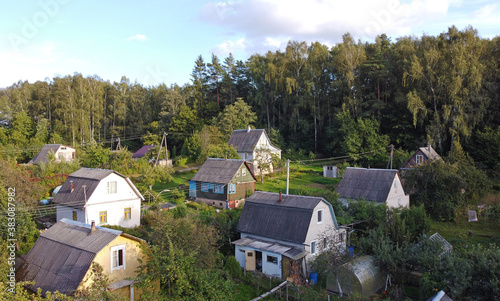 Top view of suburban villas near the park. Landscape with roofs of small houses