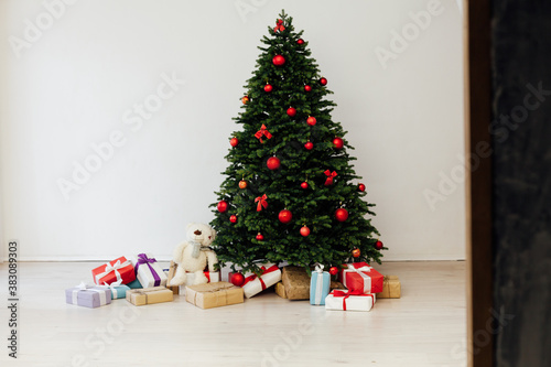 Christmas tree pine with red decor with gifts interior postcard for the new year