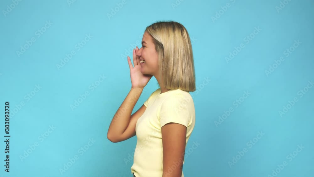 Young blonde caucasian woman shouting and holding palm near opened mouth Young blonde caucasian woman shouting and holding palm near opened mouth