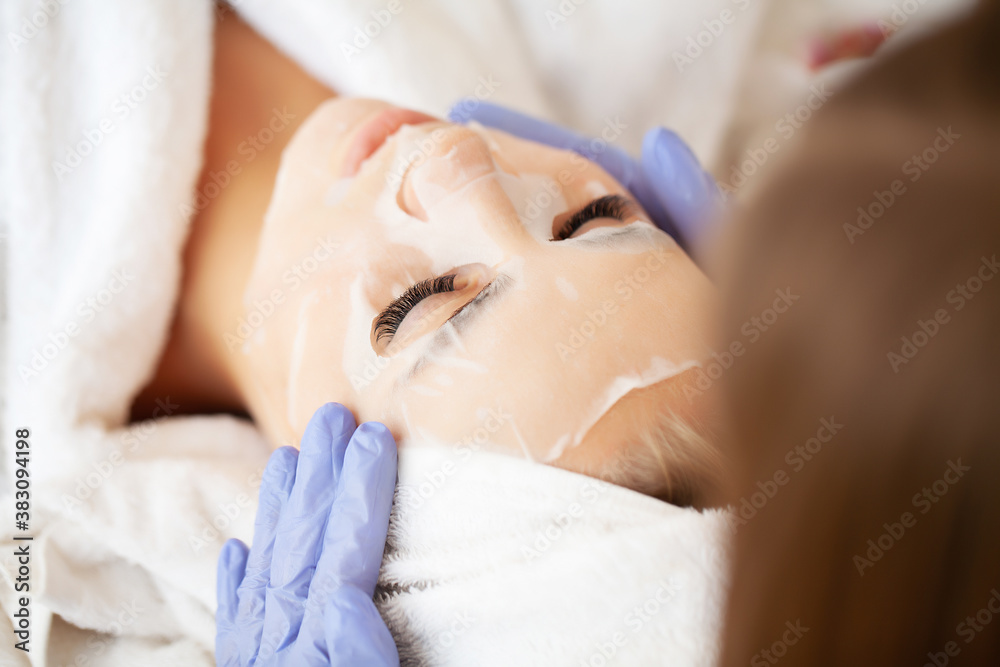 Skin care, beautiful woman with facial mask at beauty salon