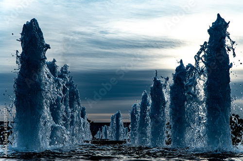 Fountains against the backdrop of the setting sun look like fantastic blocks of ice in winter in a fairyland. Russia, Moscow, Poklonnaya Gora, Victory Park.