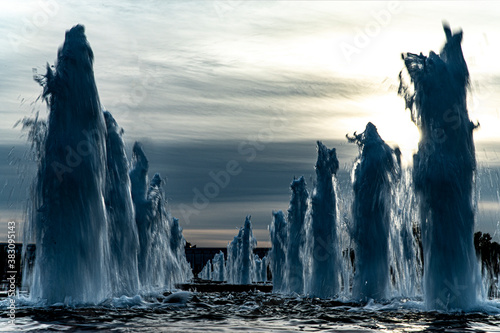 Fountains against the backdrop of the setting sun look like fantastic blocks of ice in winter in a fairyland. Russia, Moscow, Poklonnaya Gora, Victory Park.