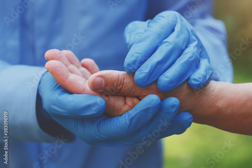 elderly health care and support concept, nurse holding senior woman's hand