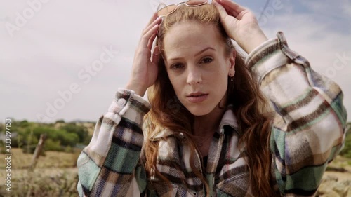Travelling of a young woman looking to the camera while taking off her sunglasses