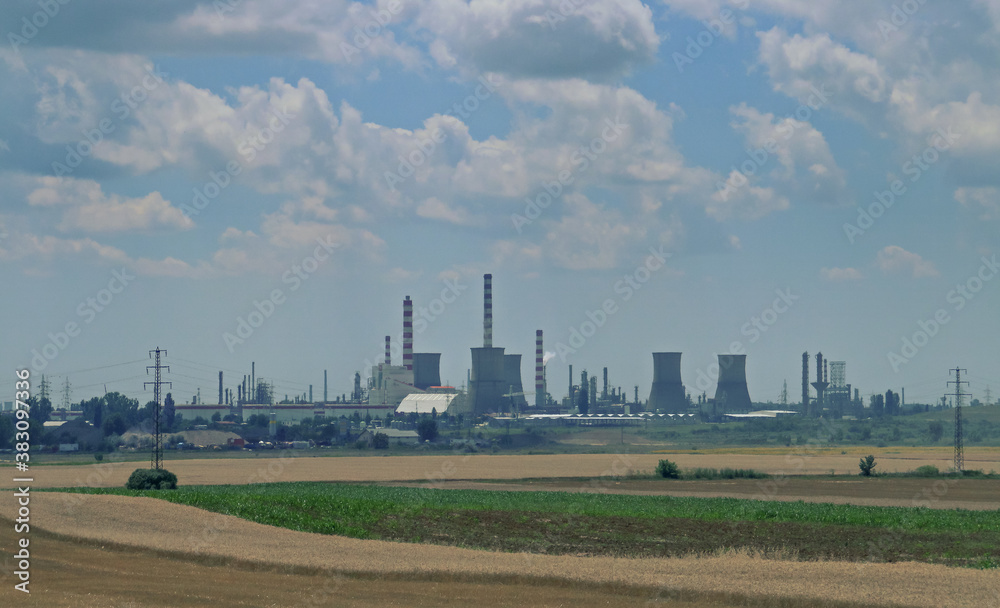 Chimeneas e instalaciones industriales en la zona sureste de Rumanía. Instalaciones entre los campos de cultivos de cereal vistas desde la carretera DN2A.