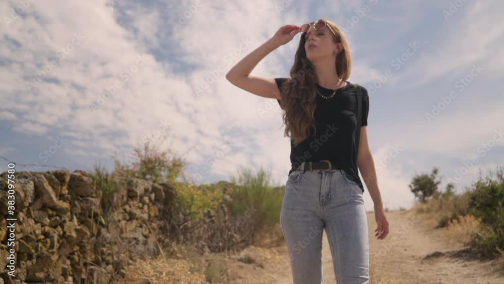 Travelling of a beautiful woman walking and enjoying the environment, takes off her sunglasses