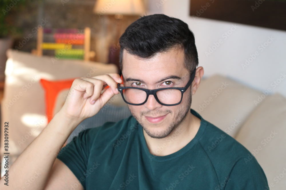 Young ethnic man holding eyeglasses
