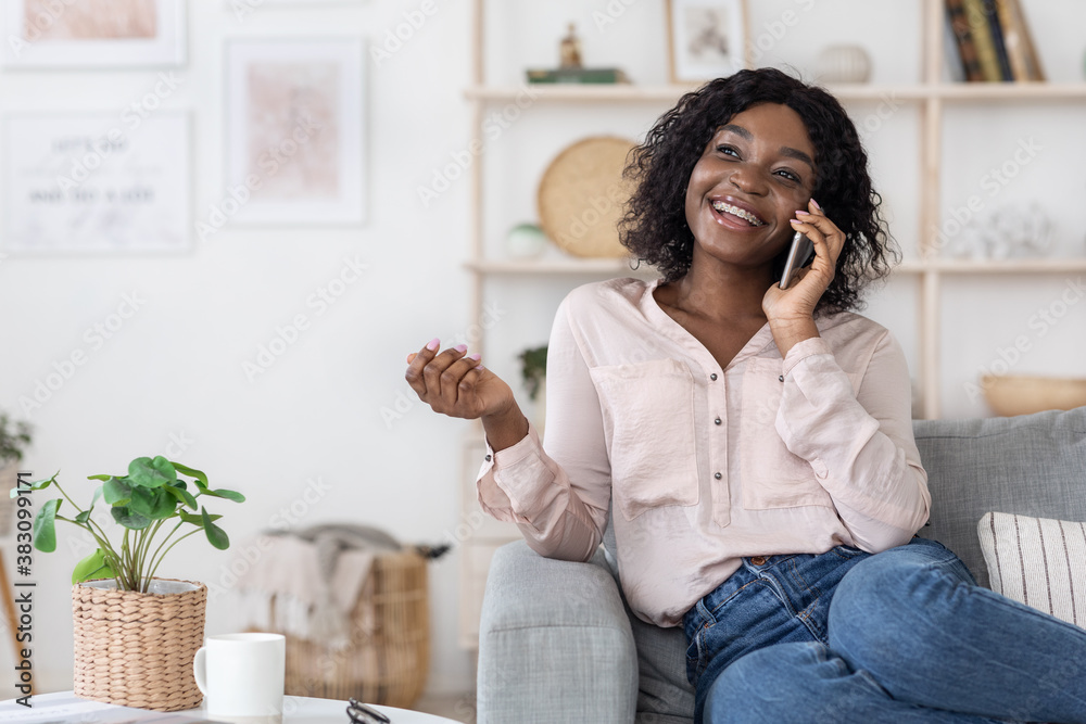 Smiling Black Woman Talking On Mobile Phone At Home With Her Boyfriend