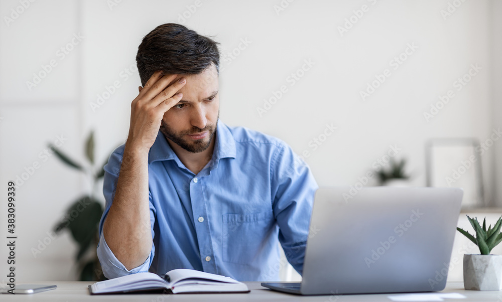 Concentrated Male Entrepreneur Looking At Laptop Screen While Working In Modern Office Concentrated Male Entrepreneur Looking At Laptop Screen While Working In Modern Office