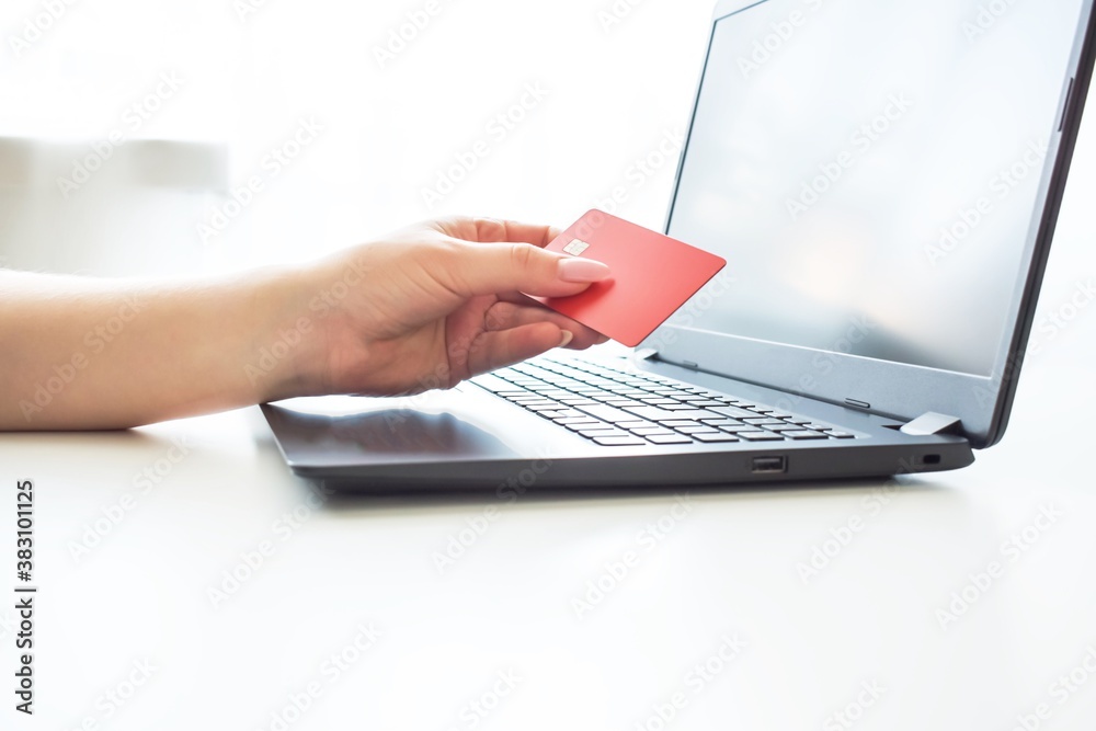 Online store. Purchase online. Paper boxes and credit cards in hand near the laptop. An online shopping service that offers home delivery. Online store. Purchase online. Paper boxes and credit cards in hand near the laptop. An online shopping service that offers home delivery.