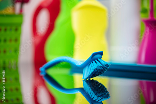 House and office cleaning theme. Colorful cleaning kit on shing glass table.