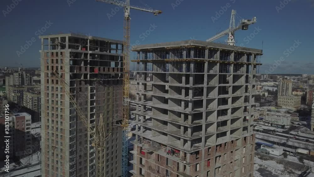 Lviv, Sychiv, Ukraine - 2 7 2020: Tower cranes work during the construction of a multi-story building. New apartments for residents and premises for offices. Risky work at height. Lviv, Sychiv, Ukraine - 2 7 2020: Tower cranes work during the construction of a multi-story building. New apartments for residents and premises for offices. Risky work at height.