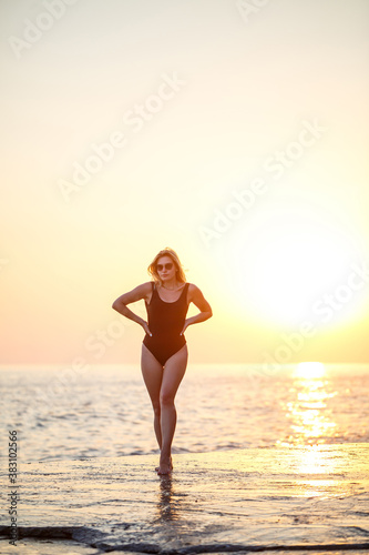 Young beautiful woman enjoying the breeze on the beach. Portrait of a carefree girl relaxing at the sea. Beautiful smiling woman enjoying the sun on the beach.