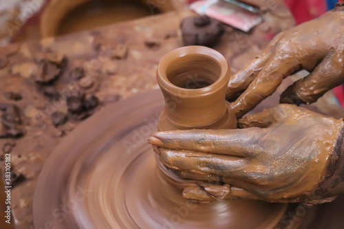 Dirty Hands Of Potter Making Pottery From Mud Using Spinning Potter Wheel