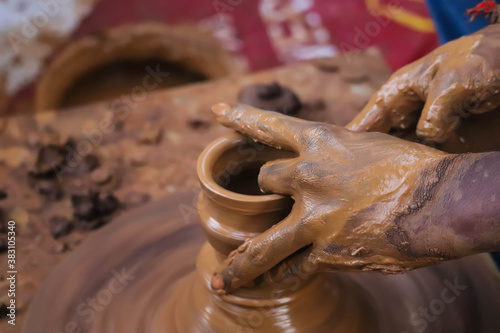 Dirty Hands Of Potter Making Pottery From Mud Using Spinning Potter Wheel