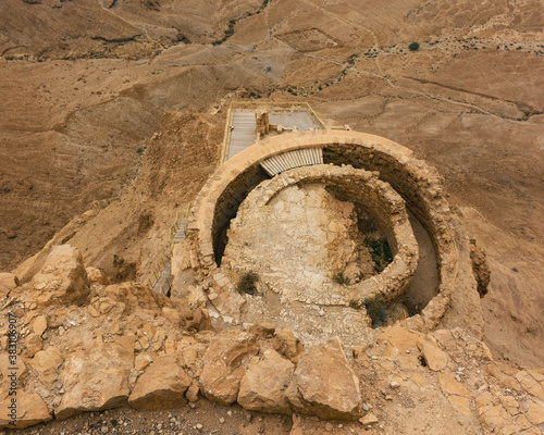 the middle terrace of the northern palace on a cloudy day at masada in israel from above with part of the lower terrace visible and a roman camp in the background photo
