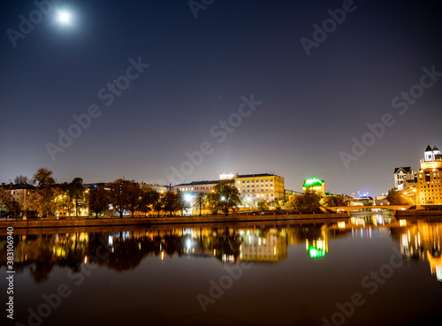 river embankment of a large metropolis at dawn with glowing lanterns reflections in the river © константин константи