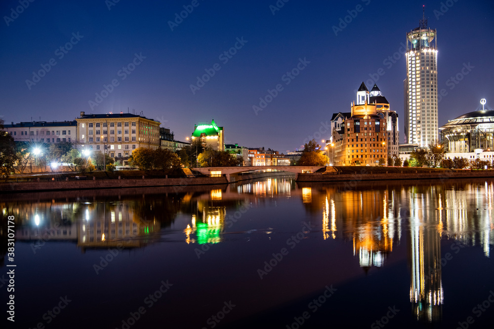 river embankment of a large metropolis at dawn with glowing lanterns reflections in the river