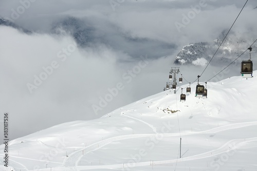 Ski lift cabins in snowy mountains in Alpe d'Huez, above the clouds