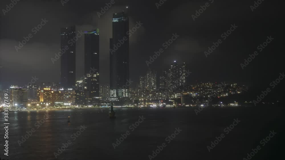 Night time lapse of Busan city in South Korea. Haeundae beach in the fog. Skyscrapers Night time lapse of Busan city in South Korea. Haeundae beach in the fog. Skyscrapers