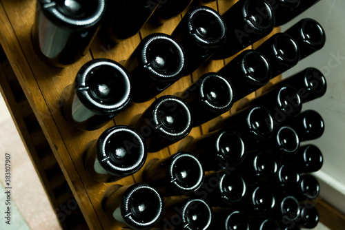 Photo of wine bottles underground, preparing process in winery at farm