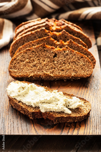 Rustic loaf of homemade bread sliced on  wooden  board