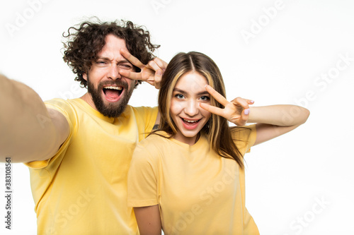 Attractive young couple taking a selfie together on white background