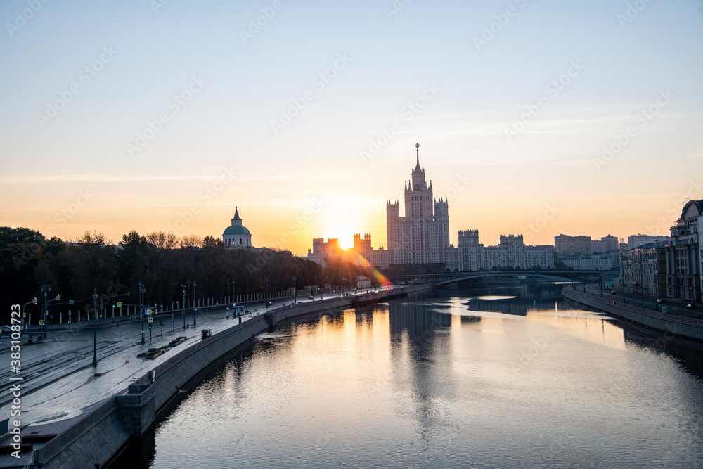 Fototapeta premium river embankment of a large metropolis at dawn with reflections in the river