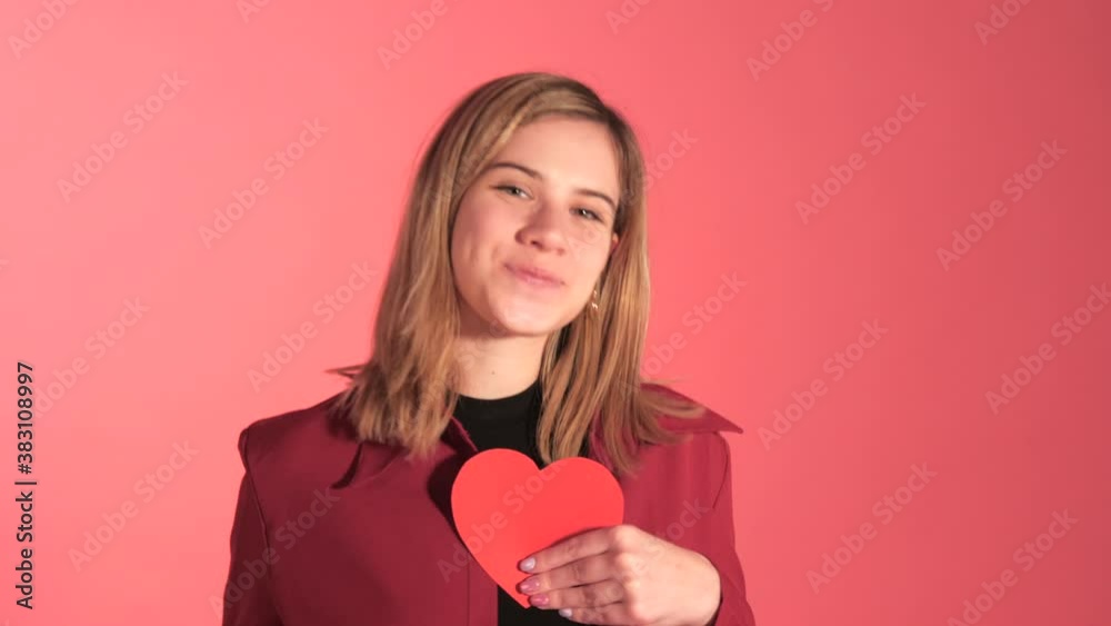 Cute Girl Points To Camera, Shows Paper Hart And Throws Kiss, Studio Shoot Cute Girl Points To Camera, Shows Paper Hart And Throws Kiss, Studio Shoot