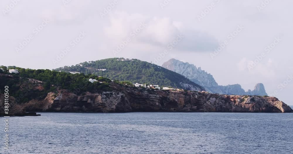 Es Vedra, Ibiza coastline, Balearic Islands, Cala Tarida cliffs and beach, stunning aerial footage of the mediterranean sea Es Vedra, Ibiza coastline, Balearic Islands, Cala Tarida cliffs and beach, stunning aerial footage of the mediterranean sea