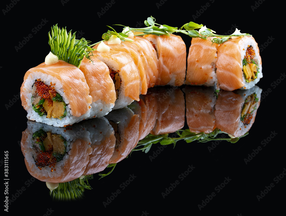 Roll Red Dragon on a black glossy background with reflection. Stuffed with salmon, tobiko, chuka, cucumber, japanese mayonnaise Roll Red Dragon on a black glossy background with reflection. Stuffed with salmon, tobiko, chuka, cucumber, japanese mayonnaise