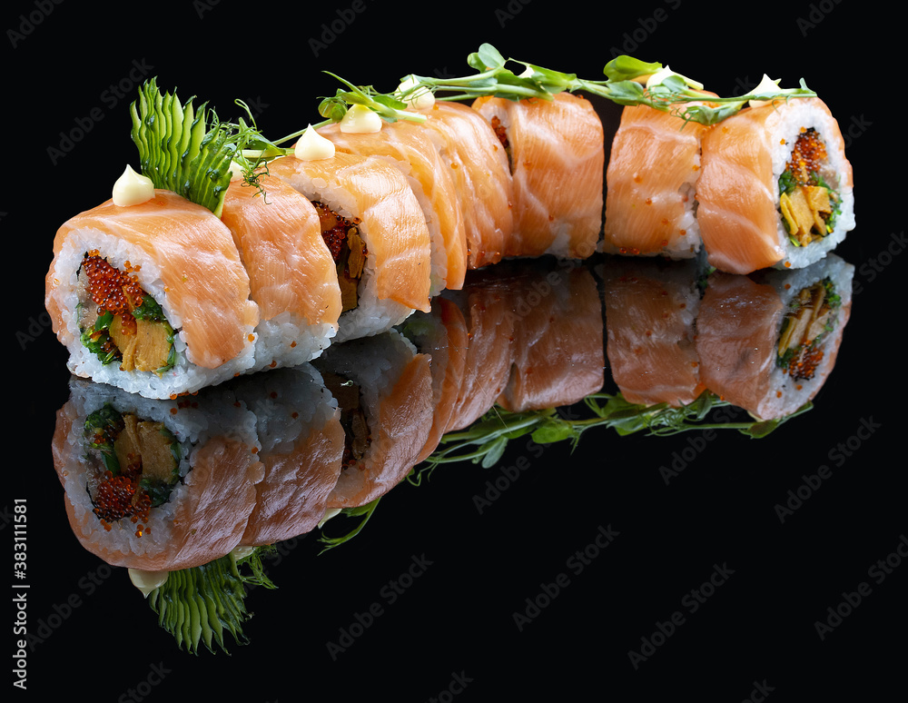 Roll Red Dragon on a black glossy background with reflection. Stuffed with salmon, tobiko, chuka, cucumber, japanese mayonnaise Roll Red Dragon on a black glossy background with reflection. Stuffed with salmon, tobiko, chuka, cucumber, japanese mayonnaise