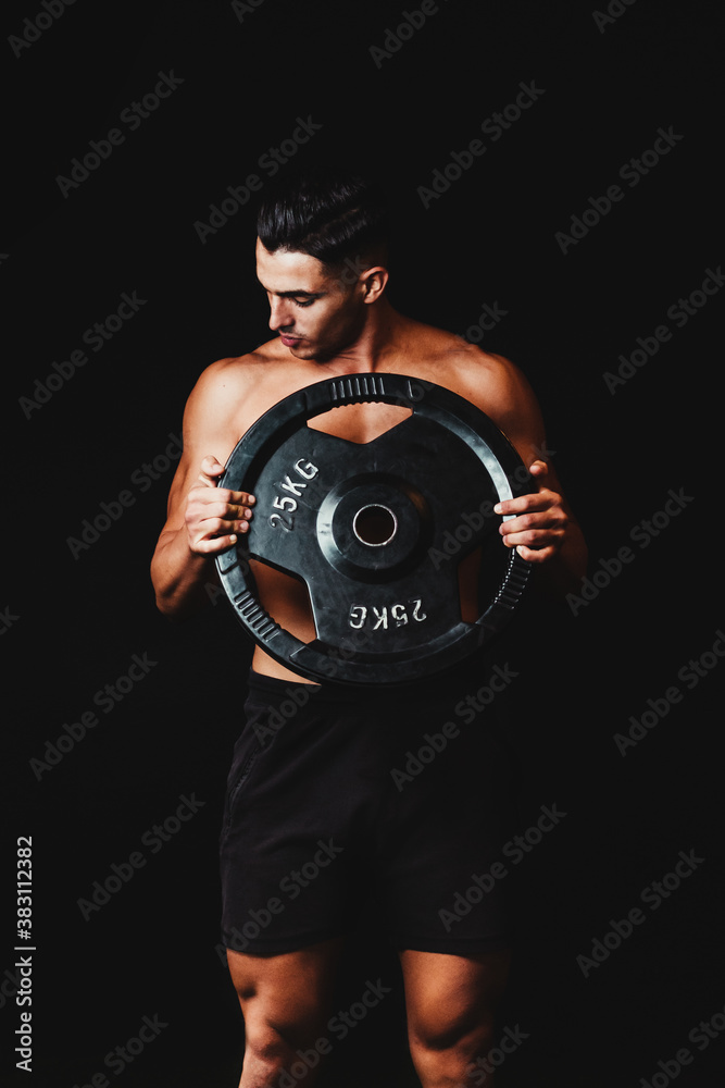 shirtless muscular man lifting a dumbbell