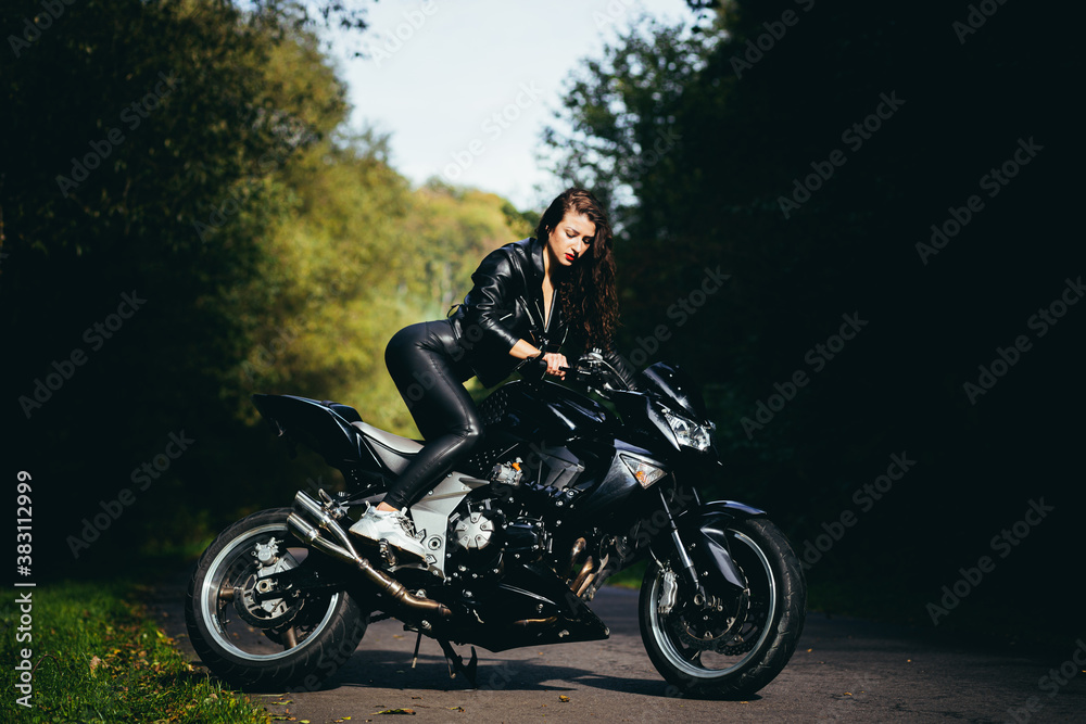 Biker sexy woman sitting on motorcycle. Outdoor lifestyle portrait