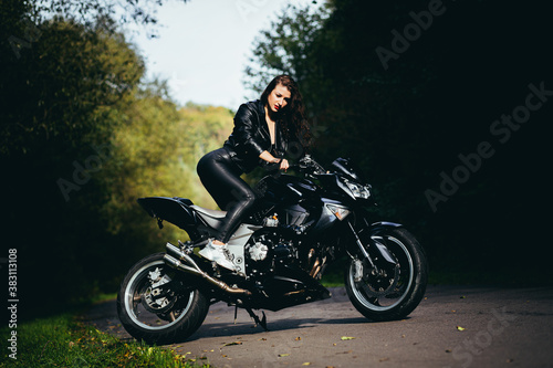 Biker sexy woman sitting on motorcycle. Outdoor lifestyle portrait