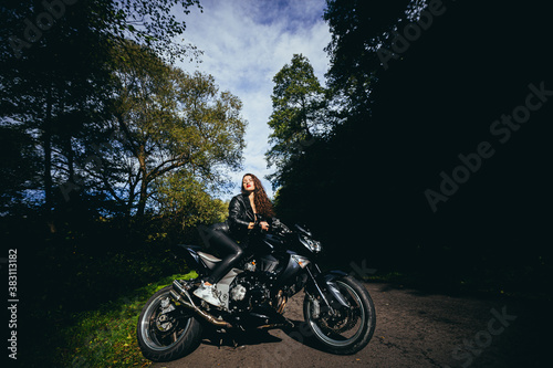 Fototapeta Naklejka Na Ścianę i Meble -  Biker sexy woman sitting on motorcycle. Outdoor lifestyle portrait