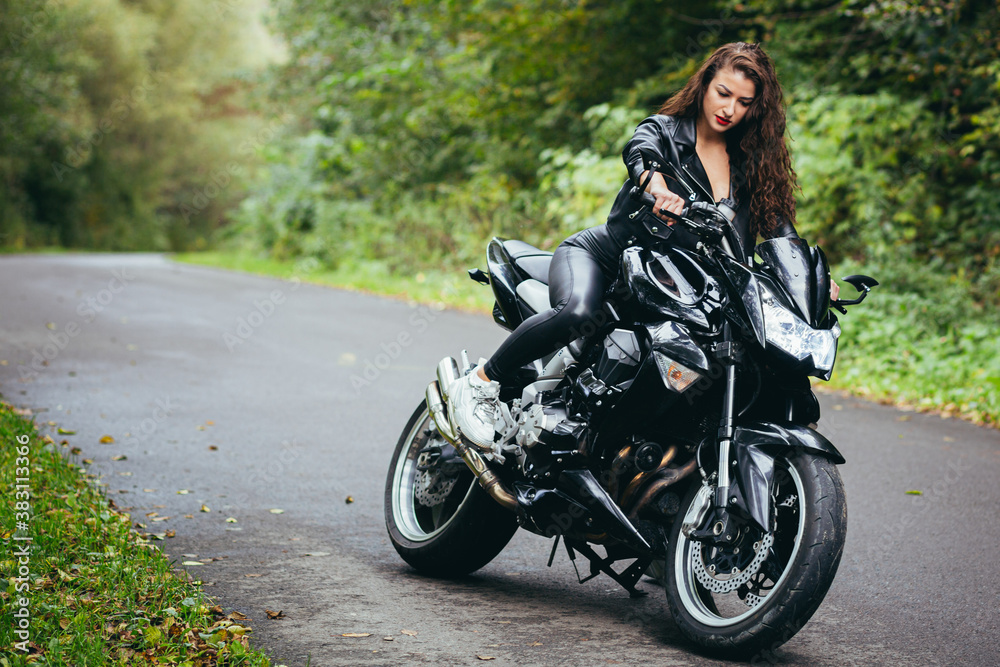 Fototapeta premium Biker sexy woman sitting on motorcycle. Outdoor lifestyle portrait