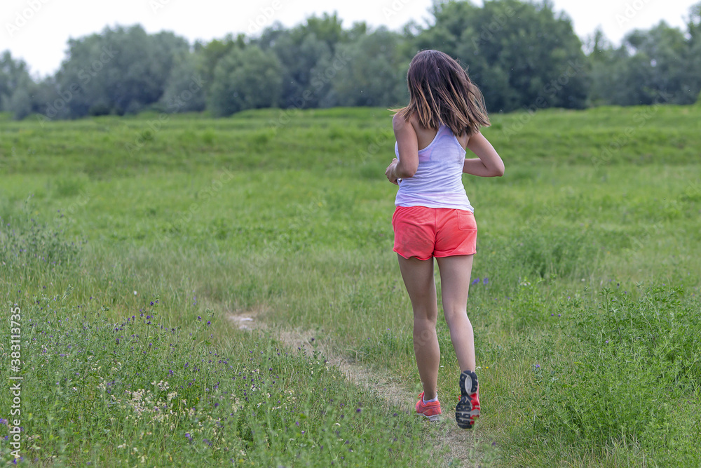 Young woman running in nature on a rural road Young woman running in nature on a rural road