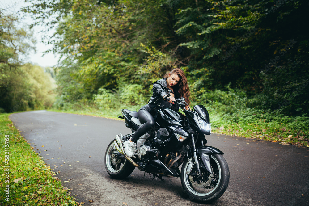 Biker sexy woman sitting on motorcycle. Outdoor lifestyle portrait