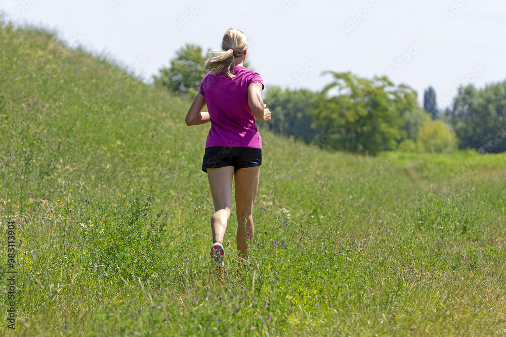 Young woman running in nature on a rural road Young woman running in nature on a rural road