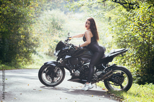 Biker sexy woman sitting on motorcycle. Outdoor lifestyle portrait