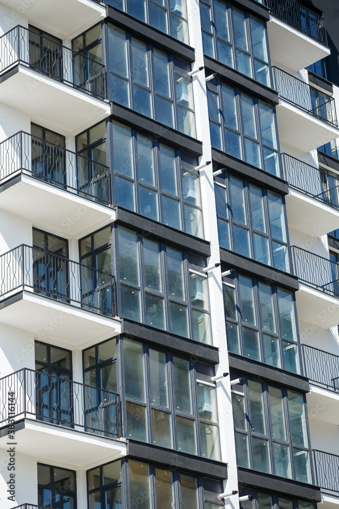 Large panoramic plastic windows. Facade of a new building in the house during construction work. Multi-storey building during construction Large panoramic plastic windows. Facade of a new building in the house during construction work. Multi-storey building during construction