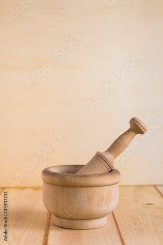 Traditional wooden mortar en pestle close up on neutral wooden background