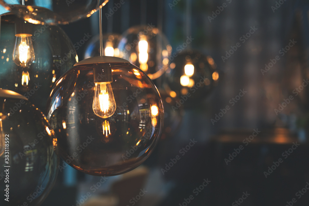 Beautiful and cosy luxury light lamp. Cosy cafe, coffee shop or lounge interior. Vintage and minimal decor. Retro vibes. Many different vintage light bulbs hanging from ceiling, coffee shop interior