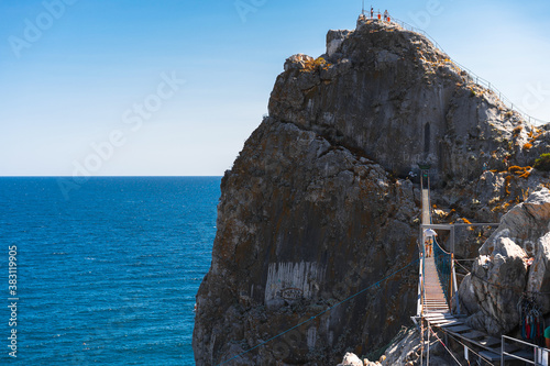 Panoramic view of the big rock in the sea with a stretched suspension bridge on the mountain in Crimea. © KseniaJoyg