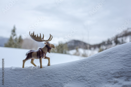 Wooden moose sculpture takes a walk uphill in the snow. Mental health awareness
