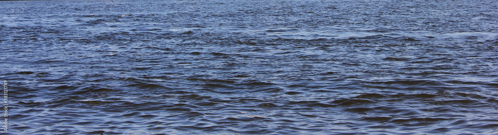 Water background. Wavy dark blue water texture, sea or river water surface background