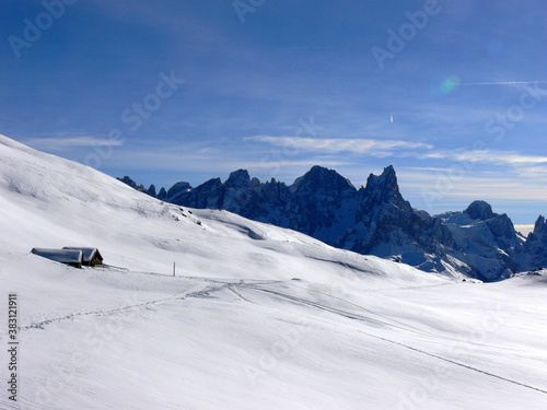 View from the top of Alpe Lusia ski area with rocky mountains and small wooden cottage in Italy 